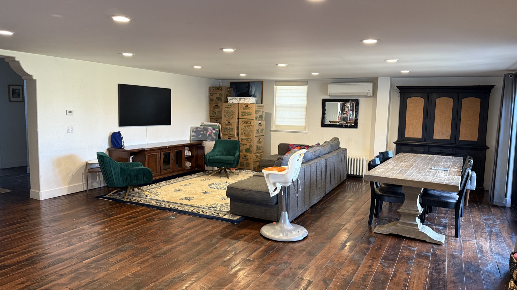 The living and dining great room before the remodel — unstyled, with moving boxes and dark floors