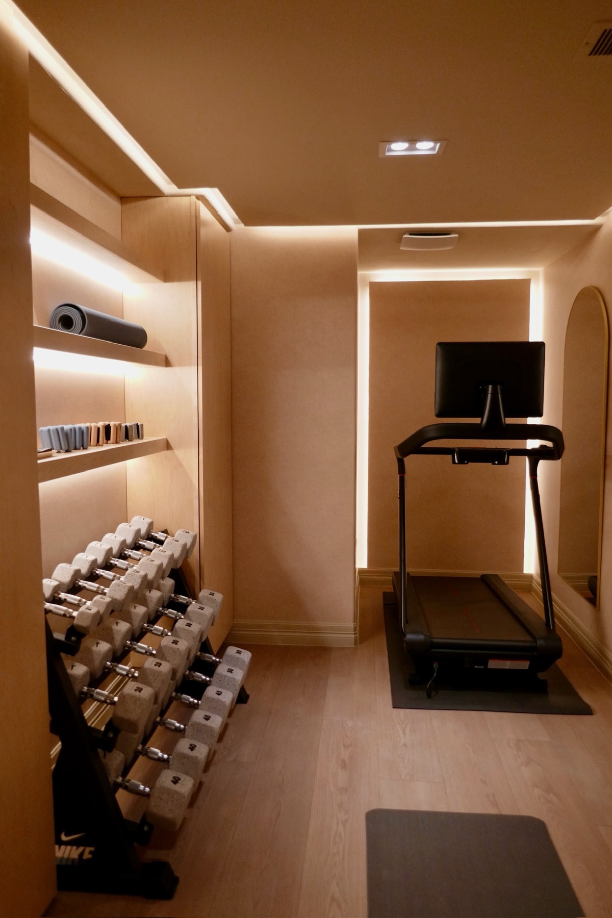 The home gym after — treadmill, arched mirror, and cove lighting