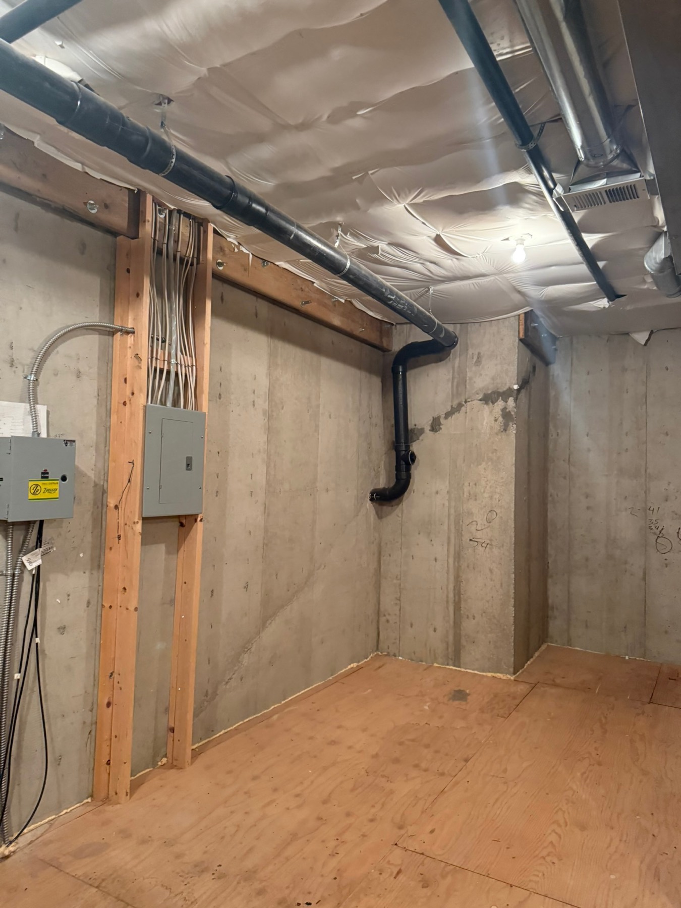 The basement before — concrete walls and exposed ducts