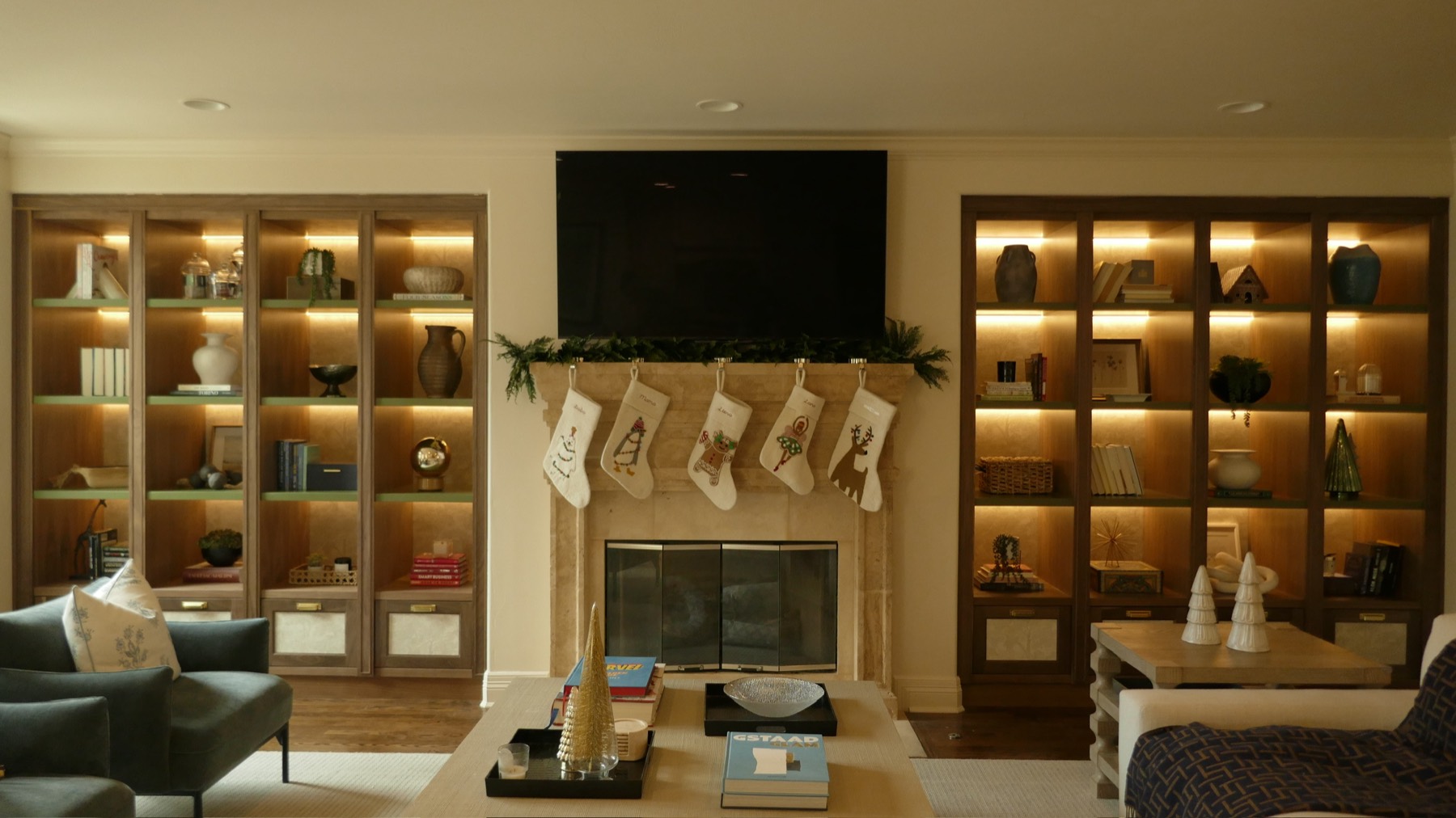 The family room after — lit walnut built-ins and a stone fireplace