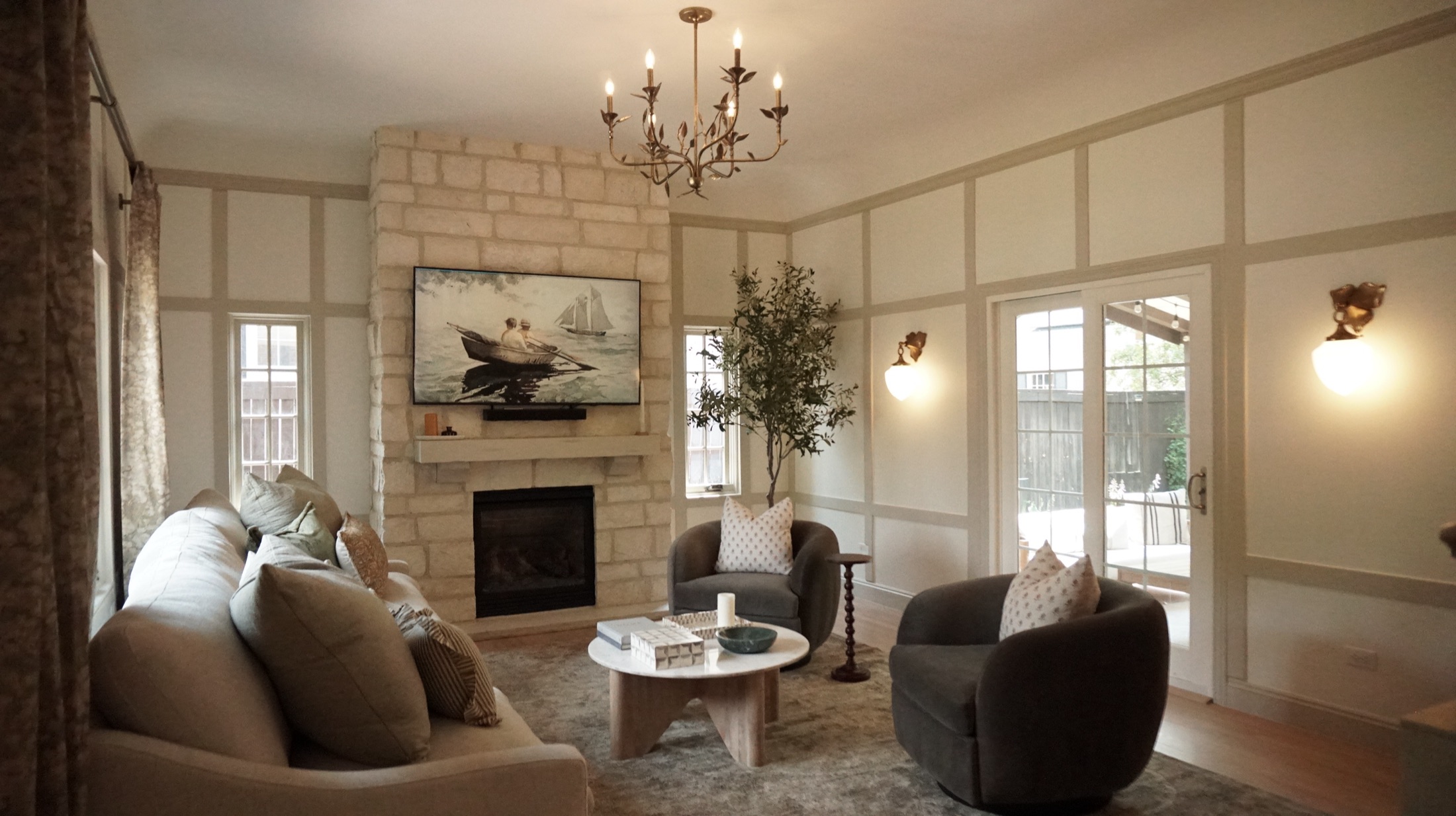 A Denver living room with a stone fireplace, olive tree, and board-and-batten walls
